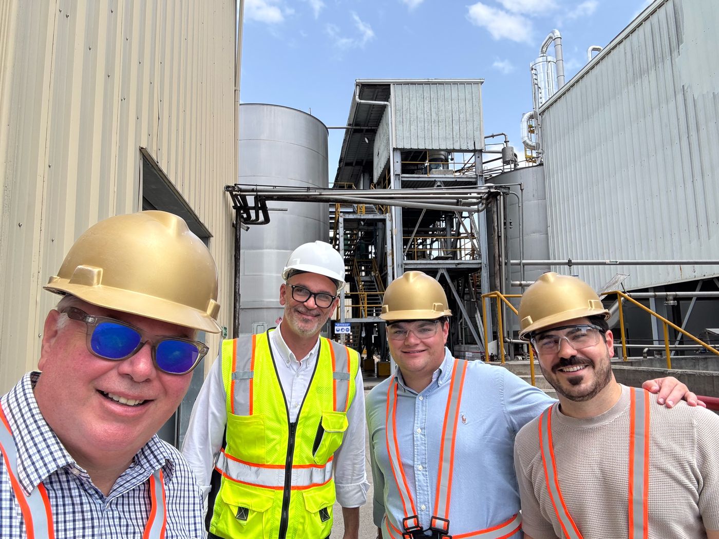 Our family with the distilling team in hard hats at the distillery